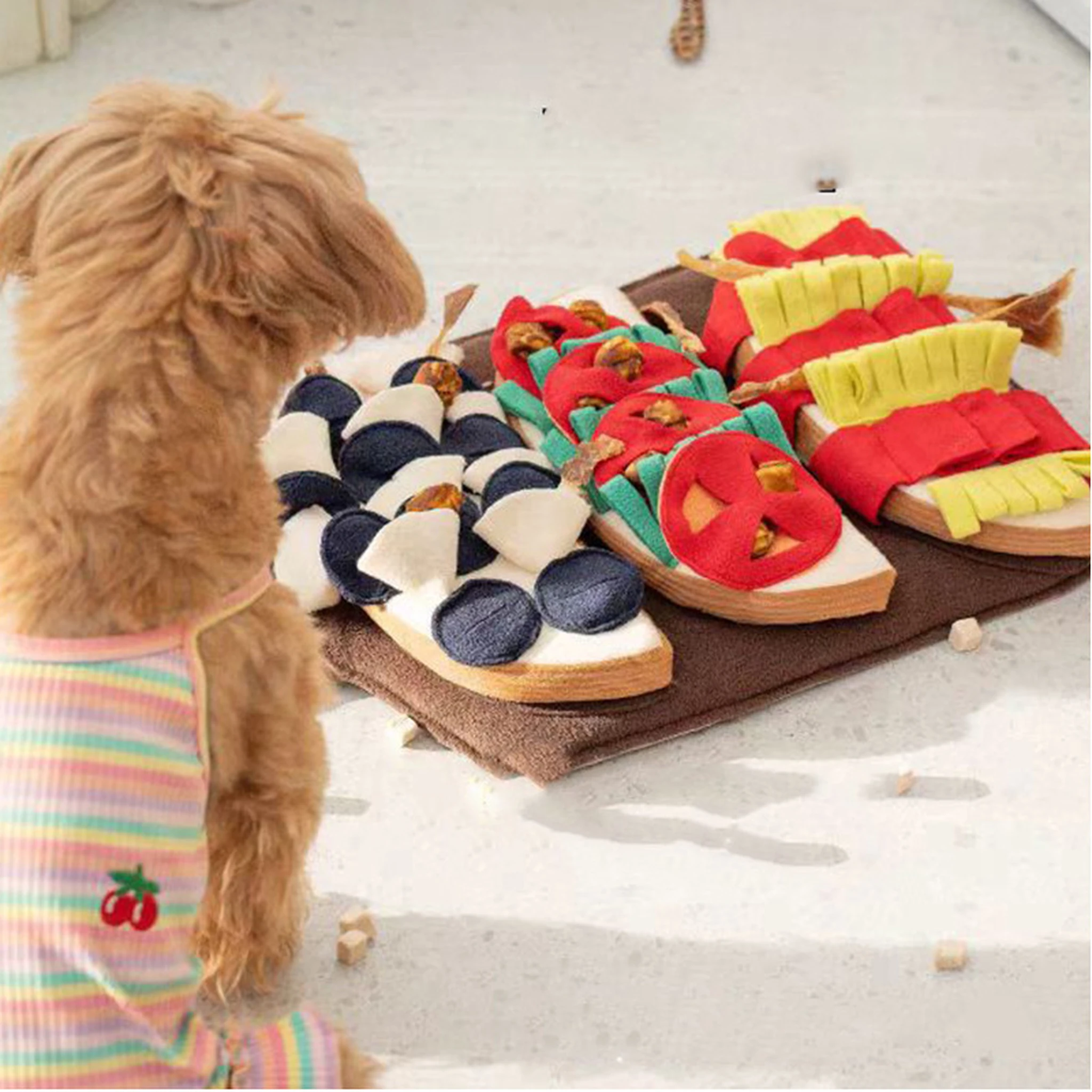 Dog beside the multicolour food-platter snuffle mat in a home setting