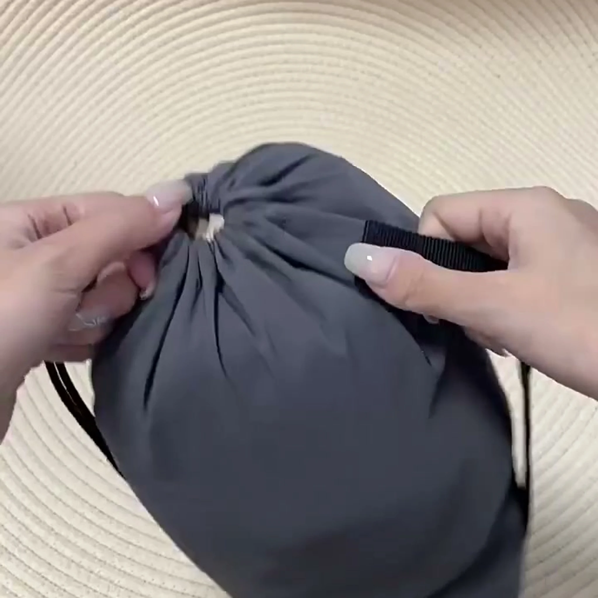 Hands adjusting drawstring on grey packed dog mat